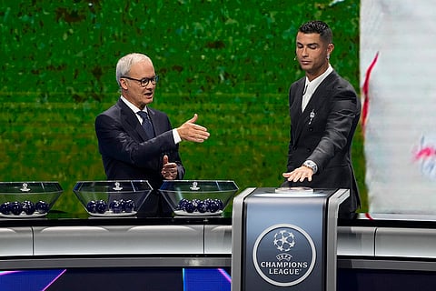 2024-25 UEFA Champions League Draw: UEFA's Giorgio Marchetti directs player Cristiano Ronaldo to press a button